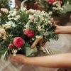 woman-s-hand-holding-basket-pf-fresh-flowers